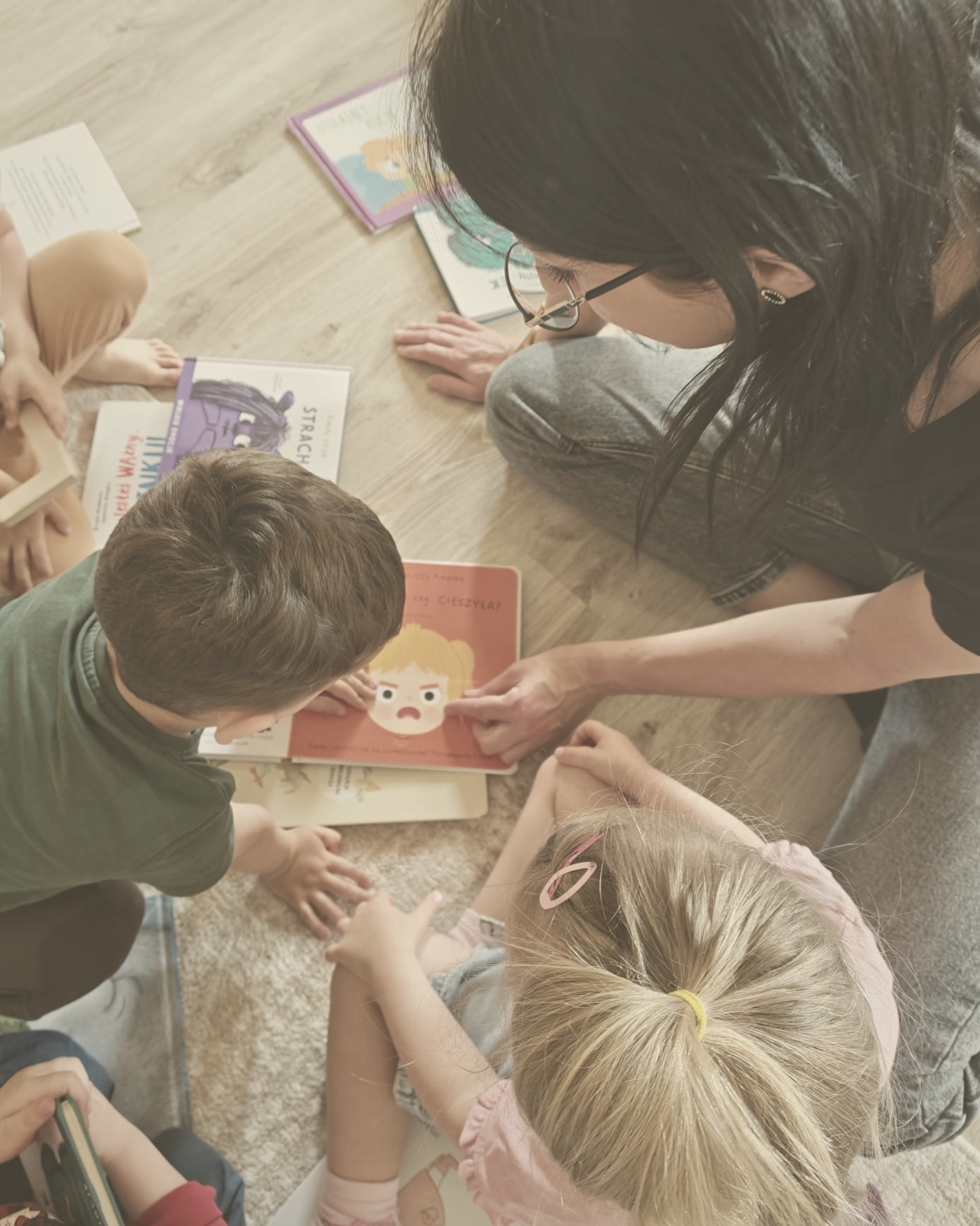 Pedagożka czyta dzieciom książkę o emocjach w żłobku